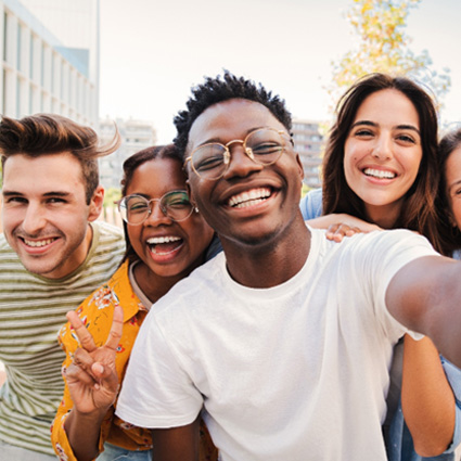 Teen in Naperville smiling with friends after Invisalign treatment