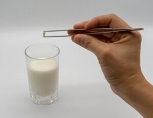 Parent putting a tooth into a glass of milk